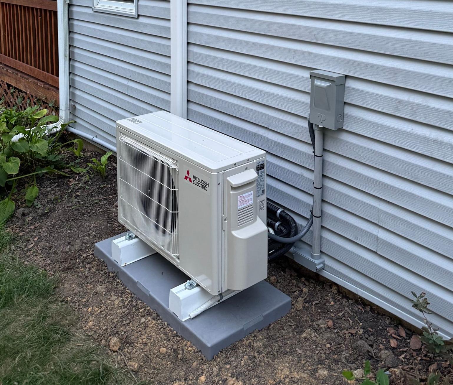 Mitsubishi Electric outdoor mini-split unit installed beside a home